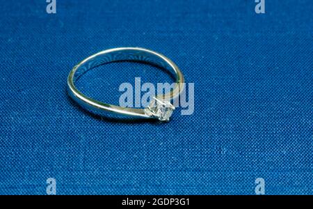 Ein Ring aus Weißgold mit einem Edelstein auf einer blauen Matte Stockfoto