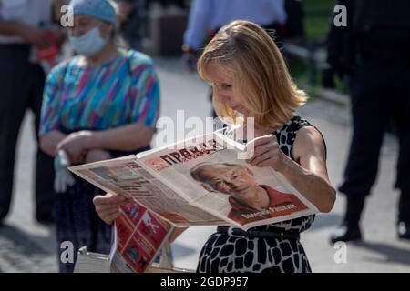 Moskau, Russland. 3. August 2021 Wähler, Teilnehmer eines Treffens mit Abgeordneten der Kommunistischen Partei der Russischen Föderation lesen die Zeitung Prawda (eng: Wahrheit) mit einem Porträt des Abgeordneten der Staatsduma Valery Raschkin auf der Titelseite der Zeitung während eines Treffens in Moskau, im Rahmen des Wahlkampfes der Kommunisten zur Staatsduma der Russischen Föderation Stockfoto