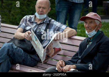 Moskau, Russland. 3. August 2021 Wähler, Teilnehmer eines Treffens mit Abgeordneten der Kommunistischen Partei der Russischen Föderation lesen die Zeitung Prawda (eng: Wahrheit) mit einem Porträt des Abgeordneten der Staatsduma Valery Raschkin auf der Titelseite der Zeitung während eines Treffens in Moskau, im Rahmen des Wahlkampfes der Kommunisten zur Staatsduma der Russischen Föderation Stockfoto