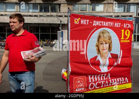 Moskau, Russland. 14. August 2021 VERTEILT EIN Freiwilliger Flugblätter zur Unterstützung der Kandidatin Nina Ostanina (aus der politischen Partei der Kommunisten) für die Abgeordnete der Staatsduma der Russischen Föderation während des Wahlkampfes in Moskau, Russland Stockfoto