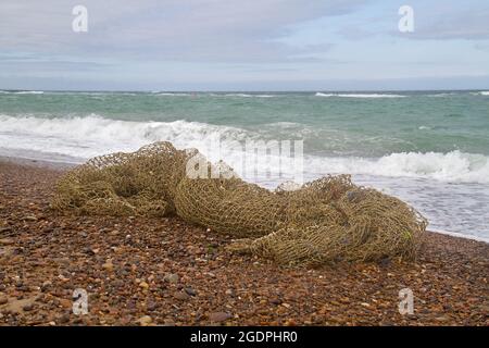 Braunes Fischernetz am Kiesstrand Stockfoto