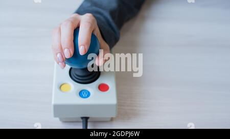 Frau mit zerebraler Lähmung arbeitet an einer spezialisierten Computermaus. Stockfoto