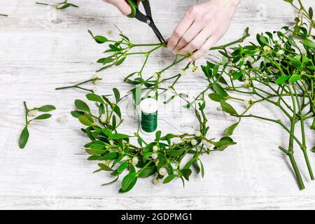 Florist bei der Arbeit: Wie man Misteltürkranz macht, Schritt für Schritt, Tutorial. Stockfoto