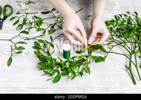 Florist bei der Arbeit: Wie man Misteltürkranz macht, Schritt für Schritt, Tutorial. Stockfoto