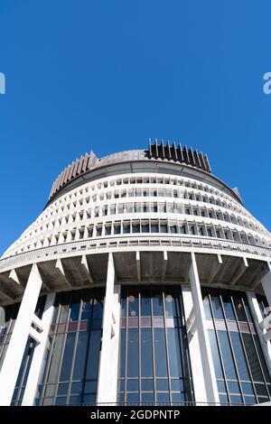 Neuseeländische Regierungsgebäude, einschließlich kreisförmigem Wahrzeichen, das als Beehive oder Executive-Flügel bekannt ist, aus der Sicht unter blauem Himmel. In vertikalem Gebäude Stockfoto