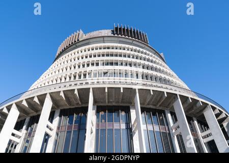 Neuseeländische Regierungsgebäude, einschließlich kreisförmigem Wahrzeichen, das als Beehive oder Executive-Flügel bekannt ist, aus der Sicht unter blauem Himmel. Stockfoto