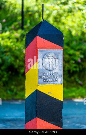 Schwarz-rot-goldener Grenzposten am Eisernen Vorhang mit Plakette: DEMOKRATISCHE REPUBLIK DEUTSCHLAND bei Sorge Stockfoto