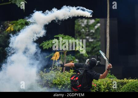 Bangkok, Thailand. August 2021. Während der Demonstration trifft ein Protestierender mit einem Tennisschläger auf eine Tränengas-Granate.Pro-Demokratie-Demonstranten treffen sich bei verschiedenen Einrichtungen, die den thailändischen Premierminister Prayut Chan-o-cha zum Rücktritt, zur Reform der Monarchie und zur Verbesserung der Politik für die COVID-19-Situation aufrufen. Die Demonstration endete mit Zusammenstößen mit der Polizei. (Foto von Amphol Thongmueangluang/SOPA Images/Sipa USA) Quelle: SIPA USA/Alamy Live News Stockfoto