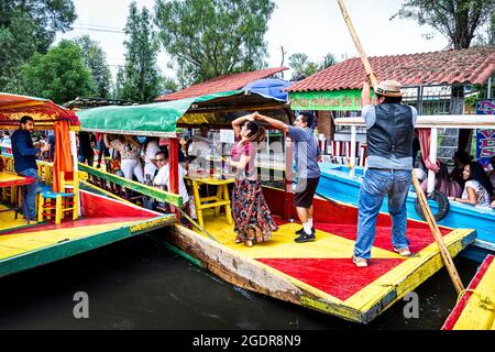 Ein Paar tanzt spontan auf einem der Boote in Xochimilco, Mexiko-Stadt, Mexiko. Stockfoto