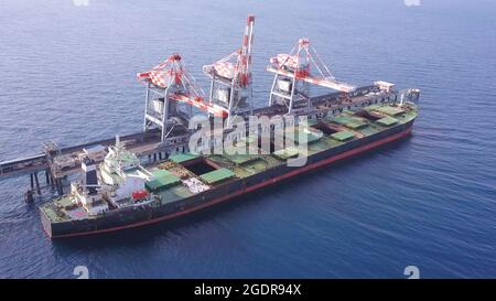 Bulk-Containerschiff entlädt Kohle im Hafen des Kraftwerks. Stockfoto