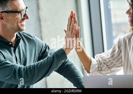 Zwei glückliche, vielfältige Kollegen, Geschäftsleute, die im Konferenzraum fünf hohe Sterne geben. Stockfoto