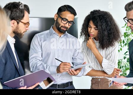 Verschiedene Manager des Führungsteams lesen den Vertrag im Sitzungssaal. Stockfoto