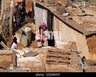 Soweto South Africa, August 15 2007; Frau hält ihr Baby vor der Tür zu ihrem Haus in einer kleinen Stadt, in der es einige Worte gibt, die ärmsten Menschen, die ums Überleben kämpfen. Stockfoto