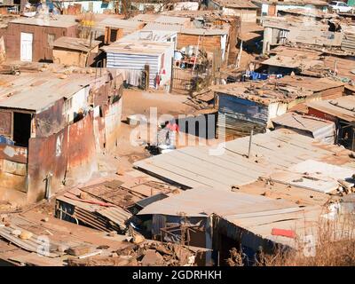 Soweto South Africa, August 15 2007; Shanty Stadt leben und Häuser von einigen der Wörter Ärmsten Menschen kämpfen, um mit Frau in der Mitte Bild tun wa zu existieren Stockfoto