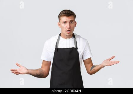 Inhaber kleiner Unternehmen, Café und Konzept des Personals. Verwirrt und besorgt Barista kann nicht verstehen, was tun, die Hände zur Seite und zuckend Stockfoto