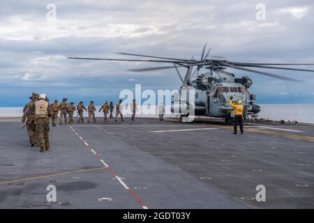 PAZIFIK (Aug 6, 2021) Seeleute und Marineinfanteristen, die dem vorwärts eingesetzten amphibischen Sturmschiff USS America (LHA 6) und der 31. Marine Expeditionary Unit (MEU) zugewiesen wurden, besteigen einen CH-53E Super Hengst-Hubschrauber vom 31. MEU für eine schnelle Seilübung. Amerika, das Flaggschiff der America Expeditionary Strike Group, ist zusammen mit der 31. MEU im Verantwortungsbereich der 7. US-Flotte tätig, um die Interoperabilität mit Verbündeten und Partnern zu verbessern und als einsatzbereite Einsatztruppe für Frieden und Stabilität in der Indo-Pazifik-Region zu dienen. (USA Navy-Foto von Mass Communication Specialist 3rd Stockfoto