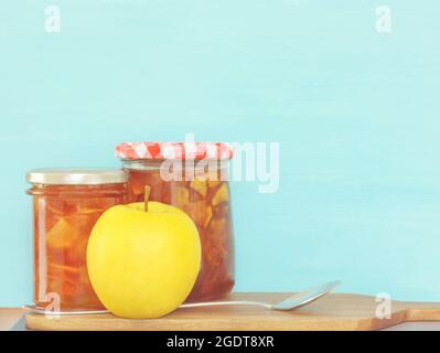 Zwei geschlossene Gläser Marmelade, gelber Apfel und Löffel, horizontales Format Stockfoto