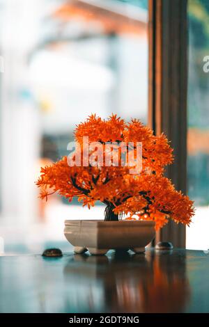 Orangefarbener künstlicher Bonsai-Baum im japanischen Restaurant mit selektivem Fokus Stockfoto