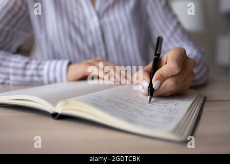 Nahaufnahme der Frau schreiben Notizen in Notizbuch Stockfoto
