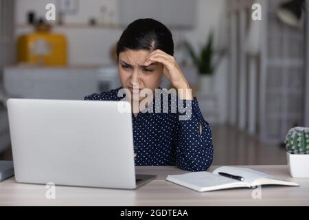 Unglückliche indische Frau fühlt sich gelangweilt, am Laptop zu arbeiten Stockfoto