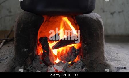 Indischer traditioneller natürlicher Lehmofen. Die Dorfbewohner kochen am Morgen mit Brennholz als Brennstoff für das Camping. Stockfoto