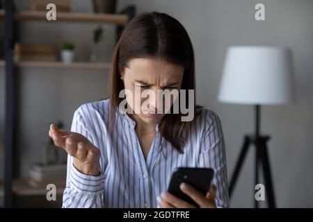 Unglückliche Frau war beunruhigt, hatte Probleme mit dem Handy Stockfoto