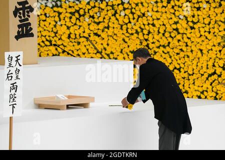 Tokio, Japan. August 2021. Yoshihide Suga, Japans Premierminister, legt während eines Gedenkgottesdienstes zum 76. Jahrestag des Endes des Zweiten Weltkriegs in Tokio, Japan, eine Blume in einer Schutzmaske auf. (Bild: © POOL via ZUMA Press Wire) Stockfoto