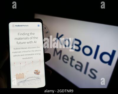 Person mit Mobiltelefon und Website des US-amerikanischen Bergbautechnikunternehmens Kobold Metals auf dem Bildschirm vor dem Logo. Konzentrieren Sie sich auf die Mitte des Telefondisplays. Stockfoto