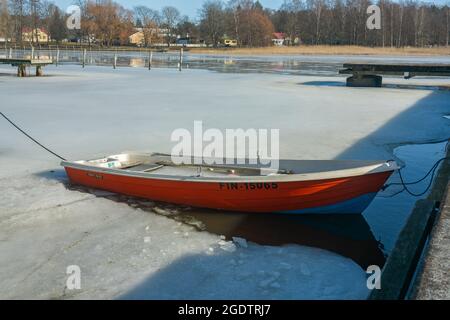 Singapur - 25. März 2021: Winter in Tammisaari Finnland. Gefrorenes Wasser mit einem kleinen Boot, das eingeschlossen ist Stockfoto