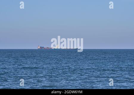 Wunderschöne Abendansicht von Fracht- und Containerschiffen in der Irischen See vom West Pier des Hafens von Dun Laoghaire, Dublin, Irland Stockfoto