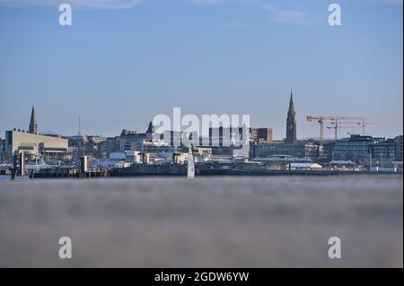 Dublin, Irland - 24. April 2021: Wunderschöne kreative Abendansicht von Dun Laoghaire mit Kirchtürmen, die vom West Pier des Hafens aus gesehen werden. Weichfokus Stockfoto