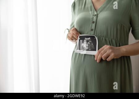 Schwanger Frau zeigt ungeborenes Baby-Sonogramm-Bild an der Kamera Stockfoto