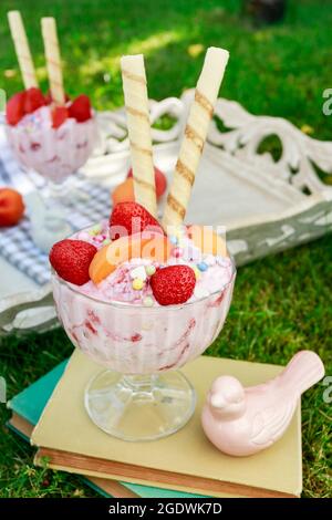 Eisdessert mit frischen Erdbeeren, Pfirsichen und knusprigen Waffelbrötchen. Party-Dessert Stockfoto