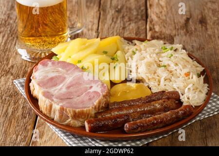 Traditionelles Oktoberfest Rezept Lebensmittel Wurst, Kassler Schweinefleisch Hals, Sauerkraut, Senf, gekochte Kartoffeln und leichtes Bier Nahaufnahme auf dem Tisch. Horizontal Stockfoto