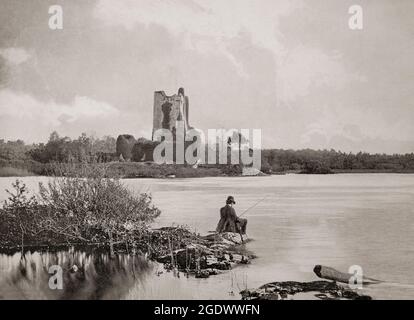 Ein Blick aus dem späten 19. Jahrhundert auf einen einsamen Fischer gegenüber den Ruinen von Ross Castle, einem Turmhaus aus dem 15. Jahrhundert und halten am Rande des Lough Leane, im Killarney National Park, (Ring of Kerry), County Kerry, Irland. Es wurde von dem lokalen herrschenden Clan der O'Donoghues Mór (Ross) errichtet, obwohl der Besitz während des zweiten Desmond Rebellion der 1580er Jahre in den Besitz der MacCarthy Mór wechselte. Danach verpachtete er das Schloss und die Ländereien an Sir Valentine Browne, den Vorfahren der Grafen von Kenmare. Die Burg gehörte zu den letzten, die sich während der irischen Konföderatenkriege Oliver Cromwell's Roundheads unterwerfen. Stockfoto