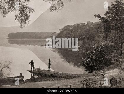Ein Blick aus dem späten 19. Jahrhundert auf Bootsmänner, die den Torc Mountain bewundern, der vom Südufer von Muckross oder Middle Lake im Killarney National Park am Ring of Kerry in der Grafschaft Kerry, Irland, aufsteigt Stockfoto