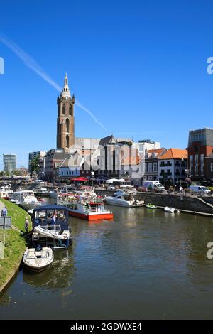 Roermond, Niederlande - Juli 9. 2021: Blick auf den geschäftigen holländischen Wasserkanal mit Stadtbild und altem Kirchturm vor blauem Sommerhimmel Stockfoto