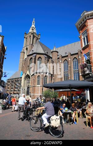 Roermond, Niederlande - Juli 9. 2021: Blick über den Platz auf die mittelalterliche alte Kirche mit geschäftigen Café gegen den Sommerhimmel Stockfoto