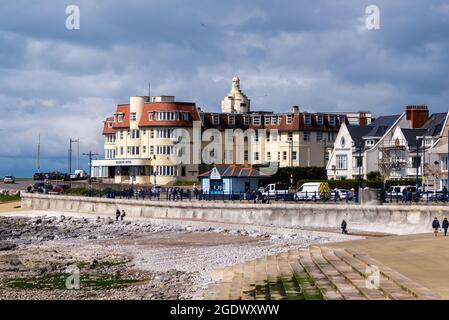 Sonniger Frühlingsmorgen mit Leuten, die entlang der Promenade vor dem großen Hotel spazieren Stockfoto