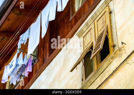 Italienisches Haus, Wäschetrocknung auf Wäscheleine und Fensterläden irgendwo in Italien, ländlich oder städtisch gleichermaßen Stockfoto