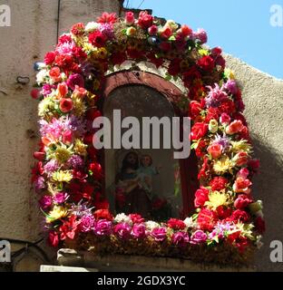 LLORET DE MAR, SPANIEN - 23. Aug 2013: Eine Nische, die wunderschön mit Blumen geschmückt ist und eine Statue des hl. Josef, der das Jesuskind trägt, in Spanien Stockfoto