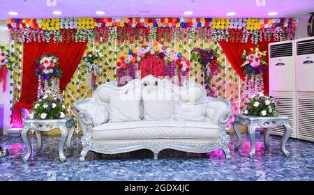 Bankettsaal Bühne mit Blumen geschmückt. Hochzeit Braut und Bräutigam White Sofa. Stockfoto