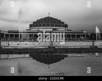 Die Centennial Hall spiegelt sich in einer Pfütze wider Stockfoto