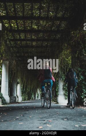 Pergola Gasse im Sommer, Radfahren Frauen Stockfoto