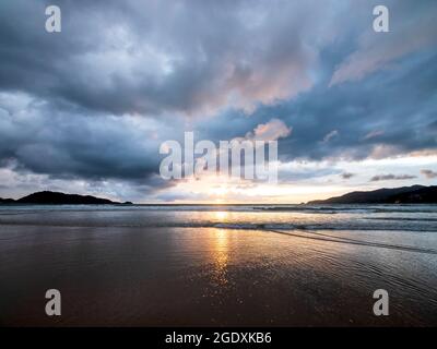 Wunderschöner Sonnenuntergang über dem ruhigen Meer mit Wolken- und Himmelshintergrund. Sonnenuntergang über tropischem Strand. Sommer-Konzept der Natur. Sonnenuntergang über dem Meer mit Gelb Stockfoto