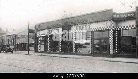 Ford Haupthändler Garage. West Riding Motor Co. Rotherham Ltd. Service Depot. Showroom mit neuem Ford Prefect auf dem Display, auch Tankstelle mit Ford Service Pick-up Truck. Gepflasterte Straße mit Straßenbahnlinien. Präfekt startete Ende 1938, Foto von damals oder Anfang 1939. Stockfoto