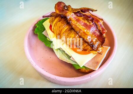 Truthahn-Sandwich auf einem Croissant mit schweizer Käse Schinken Gemüse gesundes Frühstück am Morgen Essen Stockfoto