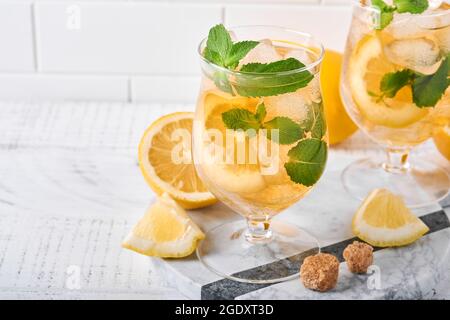 Traditioneller Eistee mit Zitrone und Eis in hohen Gläsern auf Marmortisch Hintergrund Eistee mit Zitrone. Selektiver Fokus. Erfrischung kaltes Sommergetränk Stockfoto