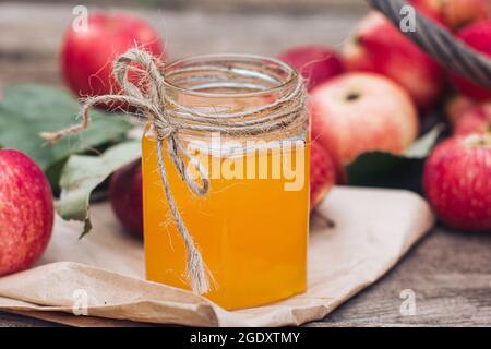 Ein Glas Honig und rote Äpfel liegen auf einem Holztisch. Herbsternte, Erntezeit, Herbststimmung. Rosh Hashanah Stockfoto