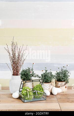 Ostertisch mit grünen Eiern, Kätzchen und saisonalen Blumen. Festliche Einrichtung Stockfoto